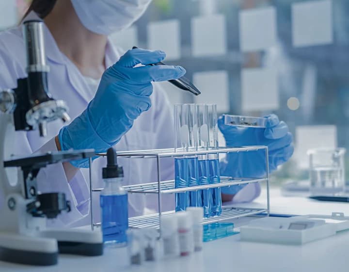 Pracownik laboratorium używający pipety do przenoszenia płynów